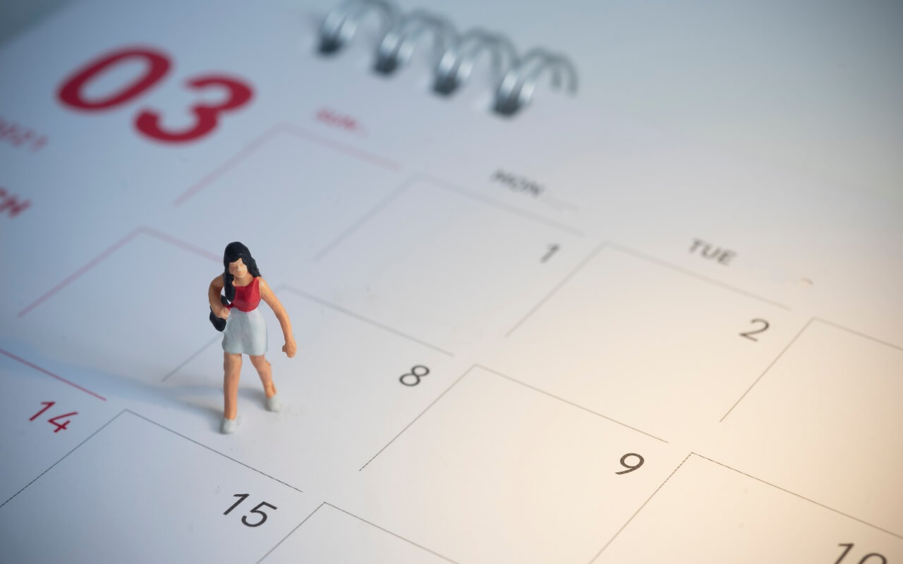 Miniature woman on calendar holiday pay