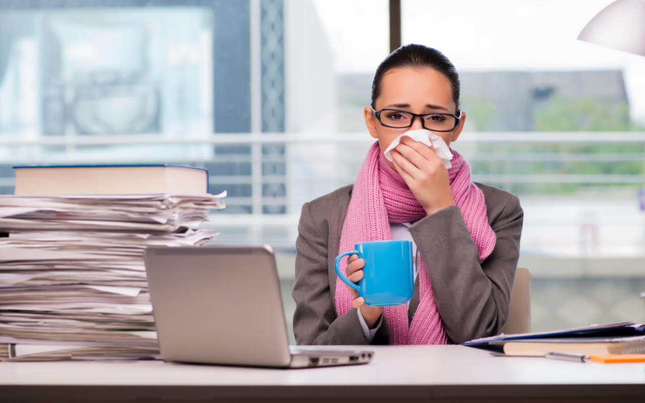 Sick employee woman in office with tissue