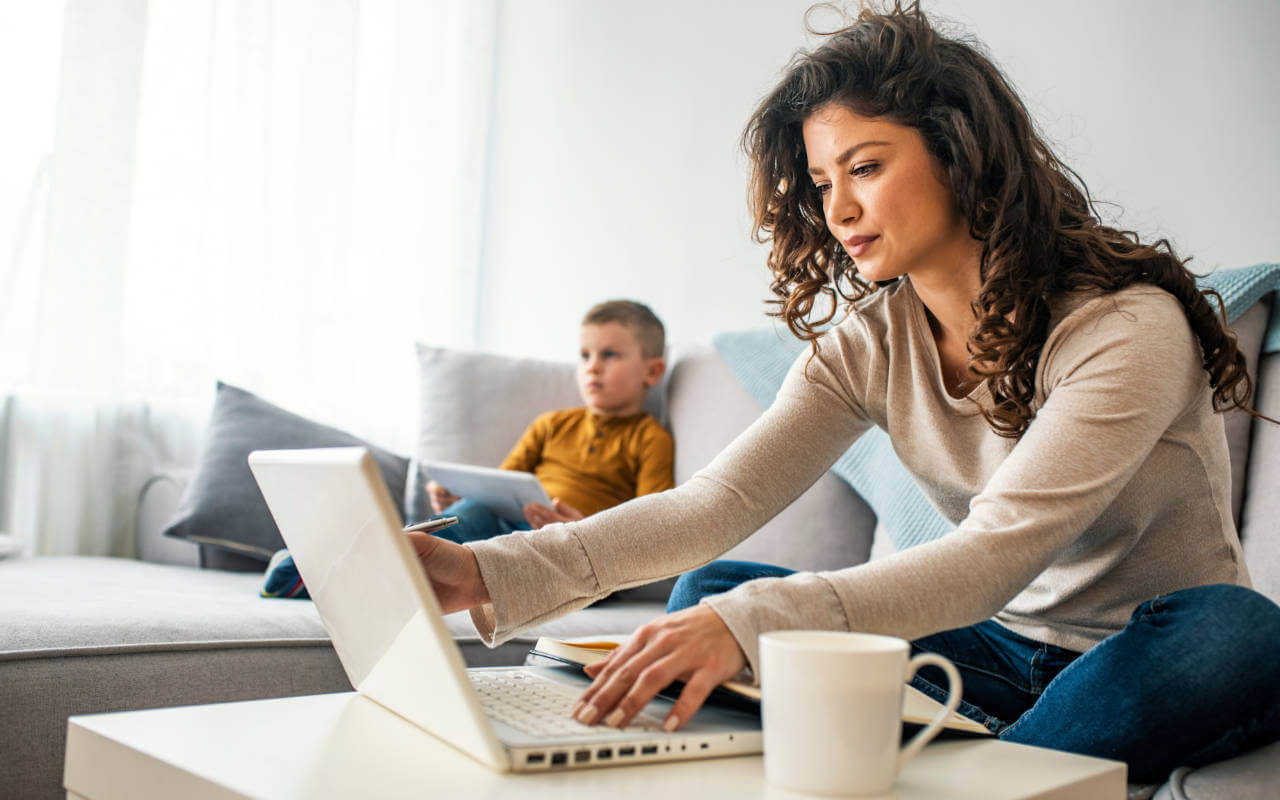 Working mother at laptop with child