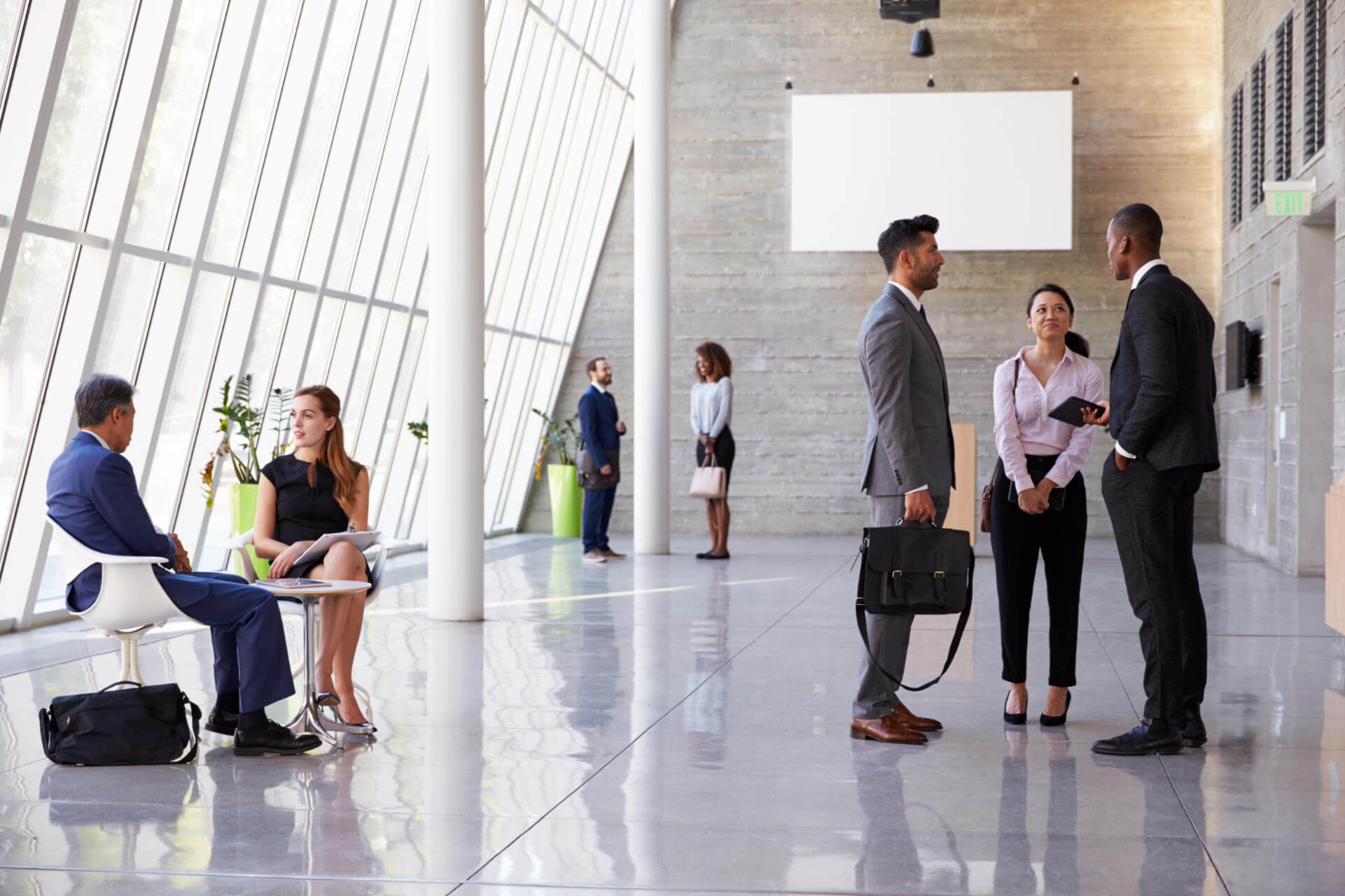 Workers stand in office foyer talking